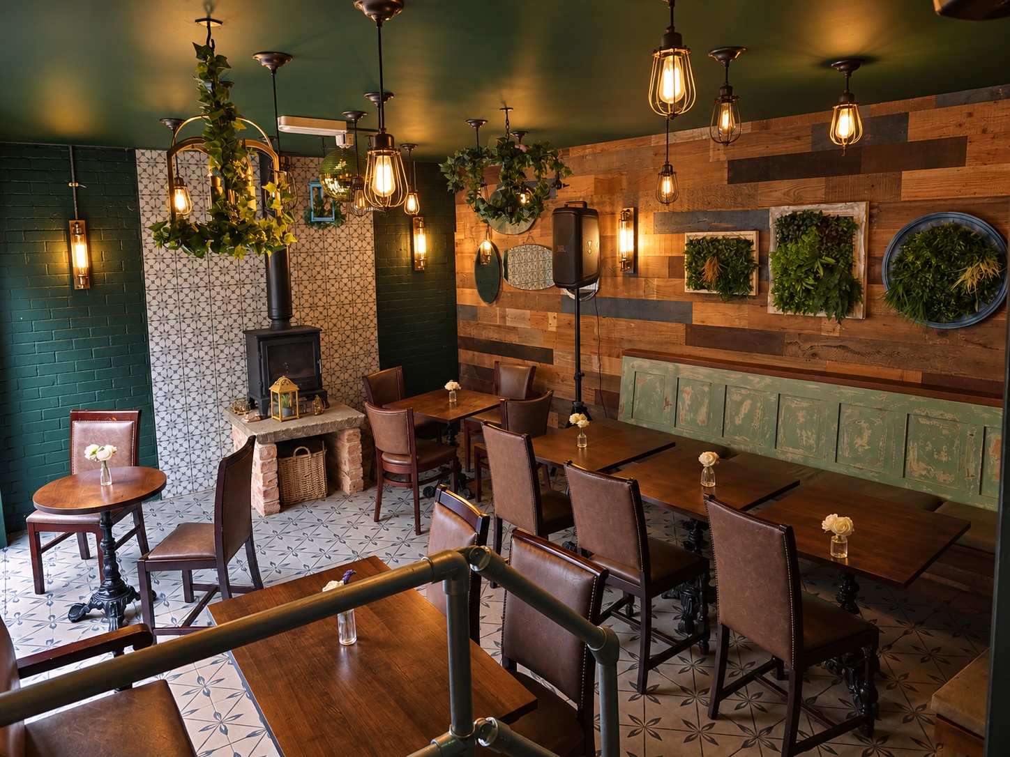 The garden room with wooden tables, hanging plants and a wood-burning stove